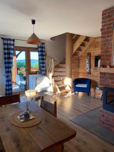 a living room with a table and chairs and a staircase at Wilcza Chata in Polańczyk