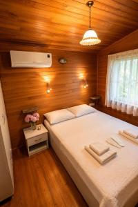 a bedroom with a large bed in a wooden room at Cirali Camping in Cıralı