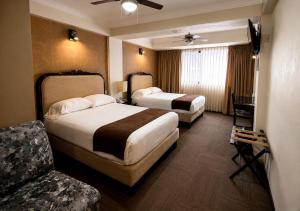 a hotel room with two beds and a television at Hotel Clara Luna in Xalapa