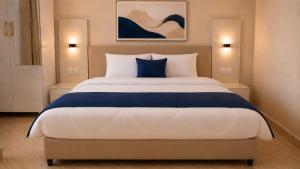a bedroom with a large bed with blue and white pillows at Cape Town K Hotel in Kigali