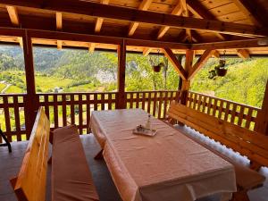 a wooden porch with a table and benches on it at Ljubav Stara Zaovine in Lazići