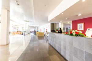 a lobby of a hospital with a counter with flowers at Hotel Eurosol Alcanena in Alcanena
