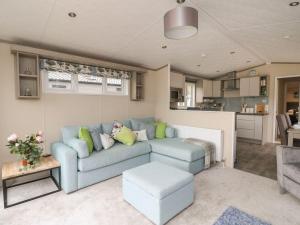 a living room with a blue couch and a kitchen at Rowan in Crieff