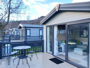 a patio with a table and chairs on a deck at Rowan in Crieff