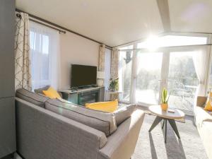 a living room with a large couch and a television at Hollybirch in Crieff