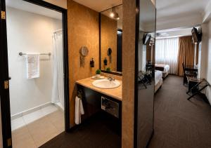 a bathroom with a sink and a room with a bed at Hotel Clara Luna in Xalapa