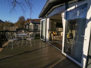 a patio with a table and chairs on a deck at Hollybirch in Crieff