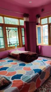 a bedroom with a bed in a room with purple walls at Samoon guest house in Wāmpor +7 photos