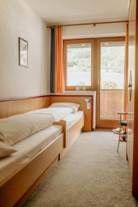 a group of beds in a room with a window at Apartment Kraftreich Apartments-4 by Interhome in Aschau
