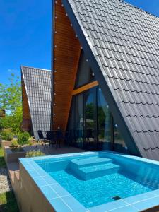 a house with a swimming pool next to a roof at Cozy Cottage Martvili in Martvili