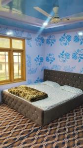 a bed in a bedroom with blue walls at Samoon guest house in Wāmpor