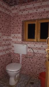 a bathroom with a toilet in a red brick wall at Samoon guest house in Wāmpor