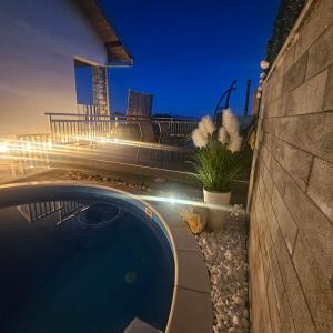 a swimming pool in a backyard at night at Vikendica Dania in Tuzla