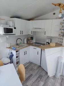 a kitchen with white cabinets and a counter top at Biały domek in Zastań +31 photos