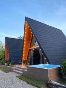 a house with a black roof and a swimming pool at Cozy Cottage Martvili in Martvili +10 photos