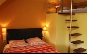 a bedroom with a bed with two lights and shelves at La Cour des Miracles Gîte in Sequehart