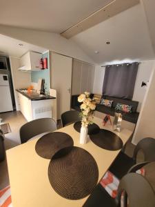 a living room with a table with flowers on it at Mobil-home MJ in Seignosse