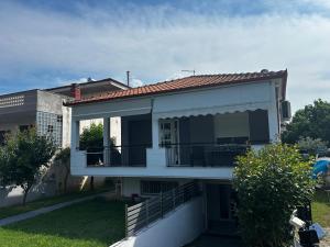 a house with a balcony and a building at Anna rooms ANTHOS GROUP in Nea Vrasna