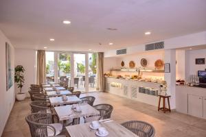 a restaurant with tables and chairs and a kitchen at INNER Hotel Rupit "Adults Only" in Cala d´Or