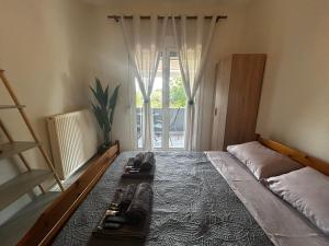 a bedroom with a bed with two controllers on it at Anna rooms ANTHOS GROUP in Nea Vrasna