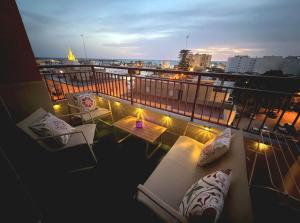 a balcony with two chairs and a table and lights at Apartamento SOLYMAR Chipiona in Chipiona