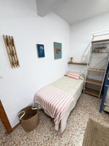 a small bedroom with a bed and a shelf at Apartamento SOLYMAR Chipiona in Chipiona