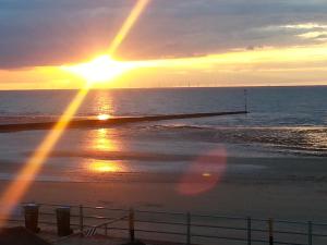 a sunset on the beach with the sun setting at Bay Lodge in Birchington