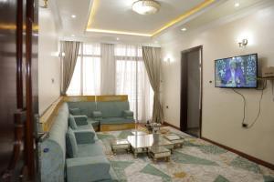 a living room with a blue couch and a tv at kaf halal guest house in Addis Ababa