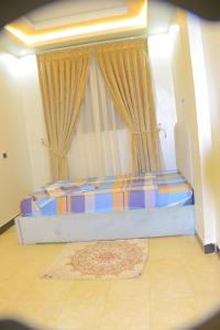 a bedroom with a bed and a window with a rug at kaf halal guest house in Addis Ababa