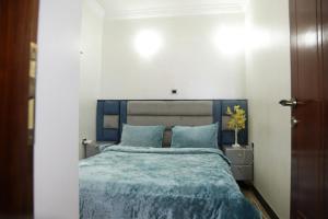 a bedroom with a bed with a blue comforter at kaf halal guest house in Addis Ababa