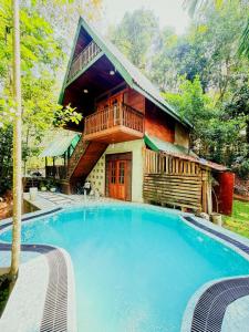 a house with a large swimming pool in front of it at Orelia villas in Badulla