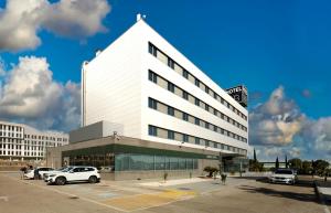 a white building with cars parked in a parking lot at Sercotel AB Rivas in Rivas-Vaciamadrid +33 photos