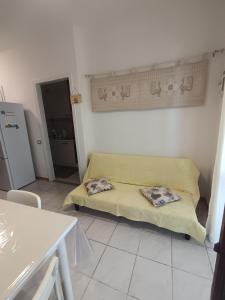a living room with a yellow couch in a room at Casa Orchidea in Villasimius