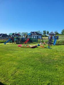 a park with a bunch of playground equipment in a field at Zielona Dolina Sarbinowo in Sarbinowo