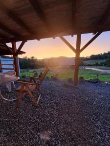 a picnic table and chair under a pavilion with the sunset at Sušice - prázdninový dům in Sušice