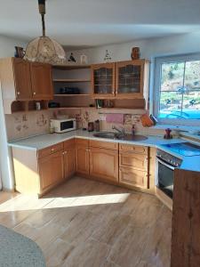 a kitchen with wooden cabinets and a sink and a window at Sušice - prázdninový dům in Sušice