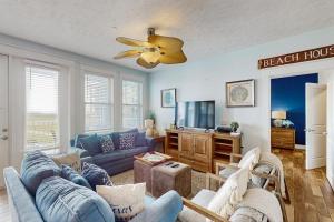 a living room with a couch and a tv at Point West Resort in Galveston