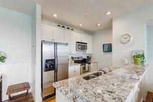 a kitchen with a refrigerator and a counter top at Point West Resort in Galveston