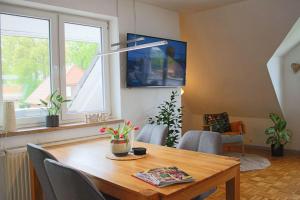 a dining room with a table and a tv at Ferienwohnung-Familie-Baasch in Embsen +4 photos