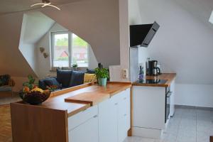 a kitchen with white cabinets and a living room at Ferienwohnung-Familie-Baasch in Embsen