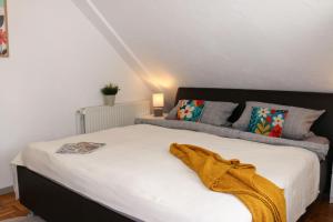 a bedroom with a bed with a yellow blanket on it at Ferienwohnung-Familie-Baasch in Embsen