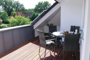 a patio with a table and chairs on a deck at Ferienwohnung-Familie-Baasch in Embsen