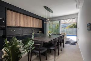 a dining room with a large black table and chairs at Villa Sunset with swimming pool in Baška
