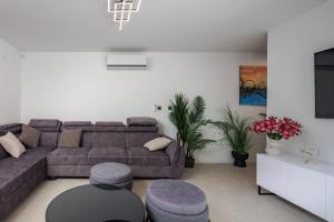 a living room with a couch and a table at Villa Sunset with swimming pool in Baška