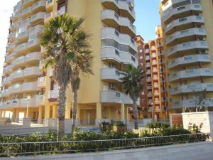 deux palmiers devant un bâtiment dans l'établissement APCOSTAS - Playa Príncipe, à La Manga del Mar Meno