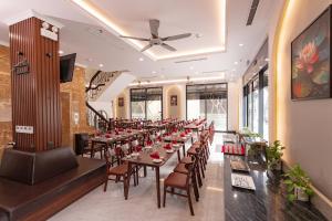 ein Restaurant mit Tischen und Stühlen in einem Raum in der Unterkunft Sun Hotel Sam Son in Sầm Sơn
