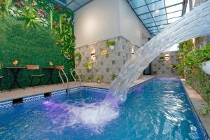 ein Schwimmbecken mit einem Springbrunnen in einem Gebäude in der Unterkunft Sun Hotel Sam Son in Sầm Sơn