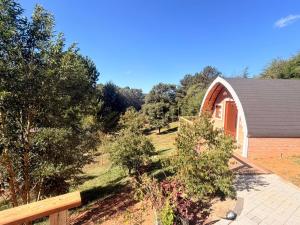 a barn with a fence next to a house at Recanto sol nascentre cabanas in Monte Verde +29 photos