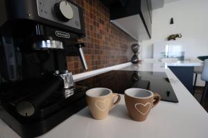 two coffee cups sitting on a counter in a kitchen at Blu Petrolio Stay-Karabas Apartments-parcheggio in Vicenza +68 photos