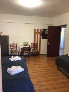 a room with two beds and a table and chairs at Pensiunea Diskret in Sovata